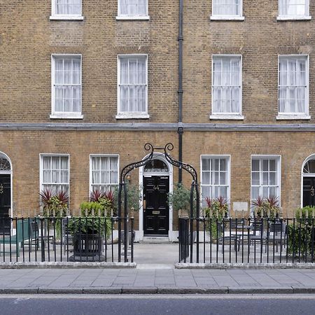 فندق Montcalm Brewery Townhouse لندن المظهر الخارجي الصورة The photo shows a row of three-story brick buildings, featuring a classic design with large windows and decorative ironwork. The buildings are painted in a muted yellow-brown color, typical of older urban architecture. In front of the buildings, ther