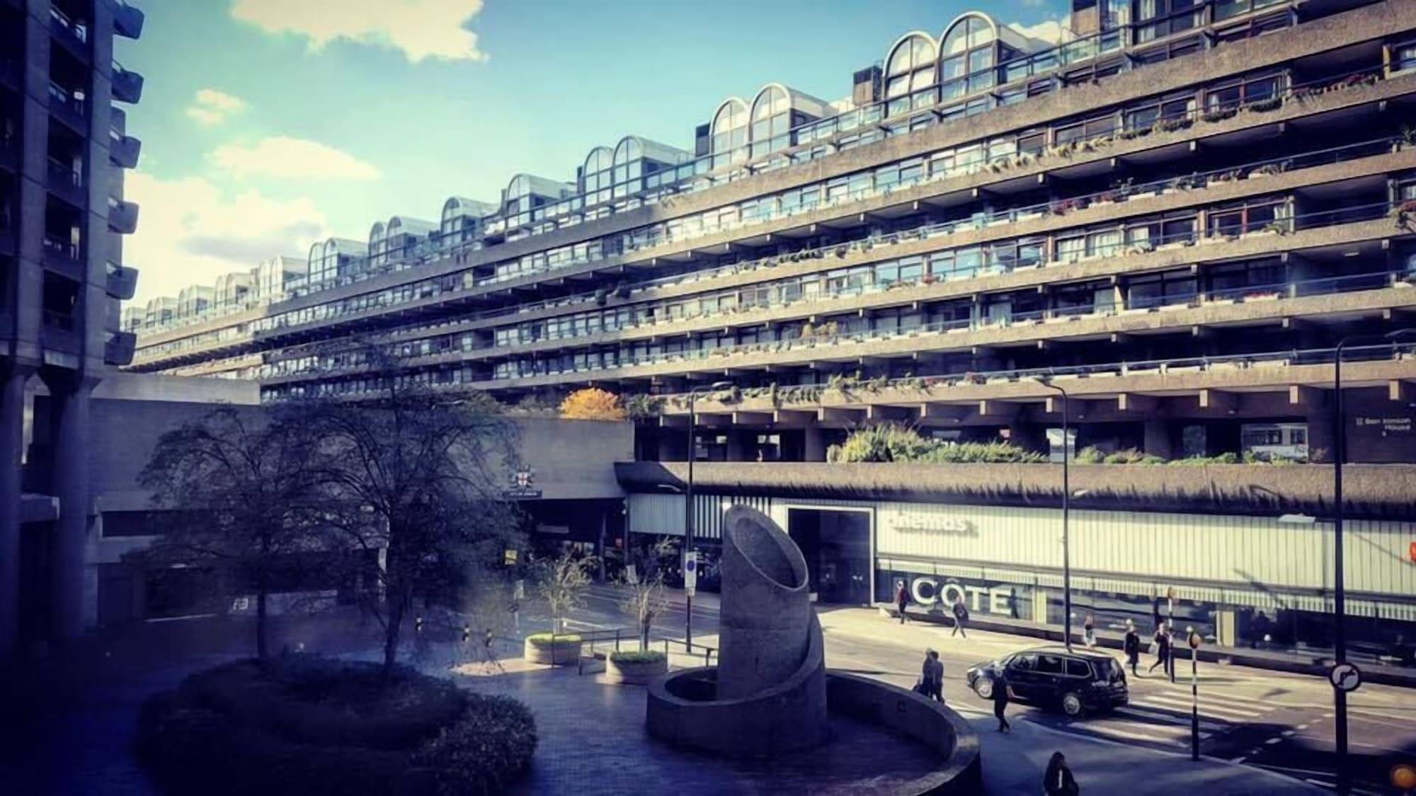 فندق Montcalm Brewery Townhouse لندن المظهر الخارجي الصورة The photo shows a modern architectural structure with multiple levels, featuring a series of large, rectangular balconies. Below this building, there is a plaza or courtyard area with a sculptural piece, which appears to be made of stone. Surrounding