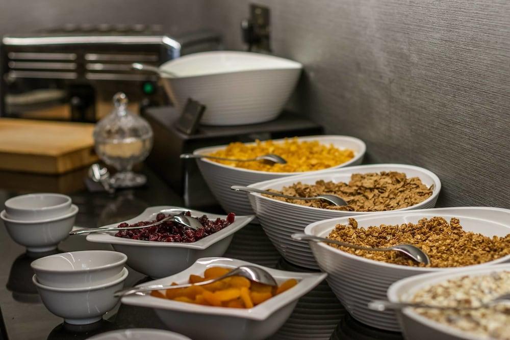 فندق Montcalm Brewery Townhouse لندن المظهر الخارجي الصورة The photo shows a variety of food items arranged on a countertop. There are several bowls containing different types of cereals and toppings. 

- One bowl features a light-colored granola.
- Another bowl holds what looks like corn flakes or a similar