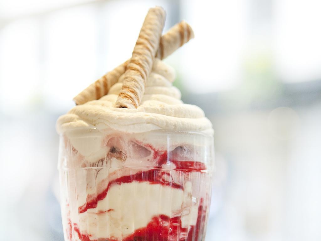 فندق Montcalm Brewery Townhouse لندن المظهر الخارجي الصورة The photo shows a delicious dessert in a clear glass dish. It features layers of creamy ice cream or whipped cream, swirled with a vibrant red fruit sauce. Topping the dessert are two rolled wafer sticks, adding a decorative touch. The overall presen