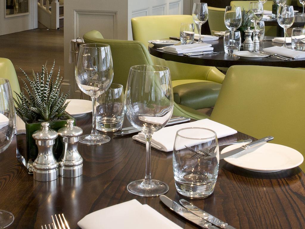 فندق Montcalm Brewery Townhouse لندن المظهر الخارجي الصورة The photo shows a dining setup in a restaurant. There are tables with a polished wooden surface and elegant place settings. Each setting includes multiple wine glasses and water glasses, neatly arranged with folded napkins. 

In the center, there are