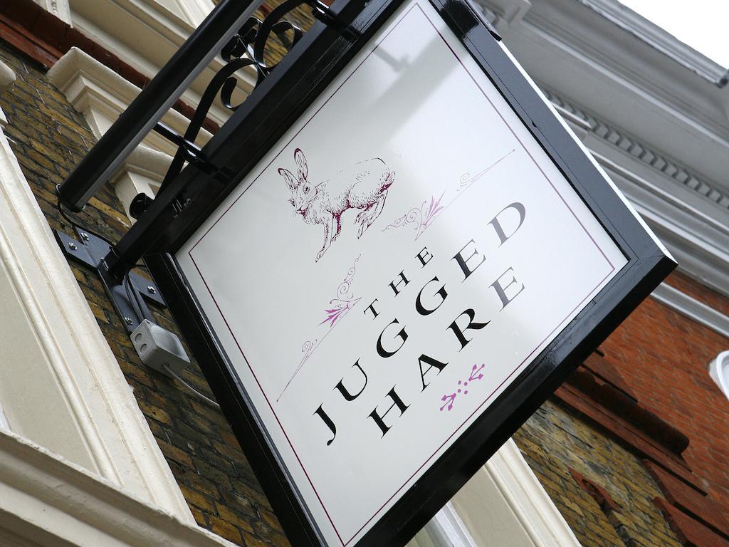 فندق Montcalm Brewery Townhouse لندن المظهر الخارجي الصورة The photo shows a hanging sign for a place called "The Jugged Hare." The design features an illustration of a hare, along with the name displayed prominently in bold letters. The overall aesthetic combines an elegant font with delicate floral accents